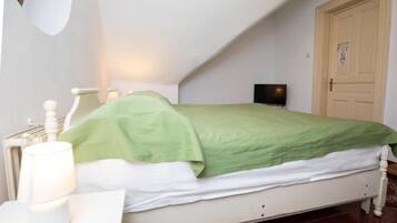 Ein Schlafzimmer mit Bett, Nachttisch, Lampe und Tür.