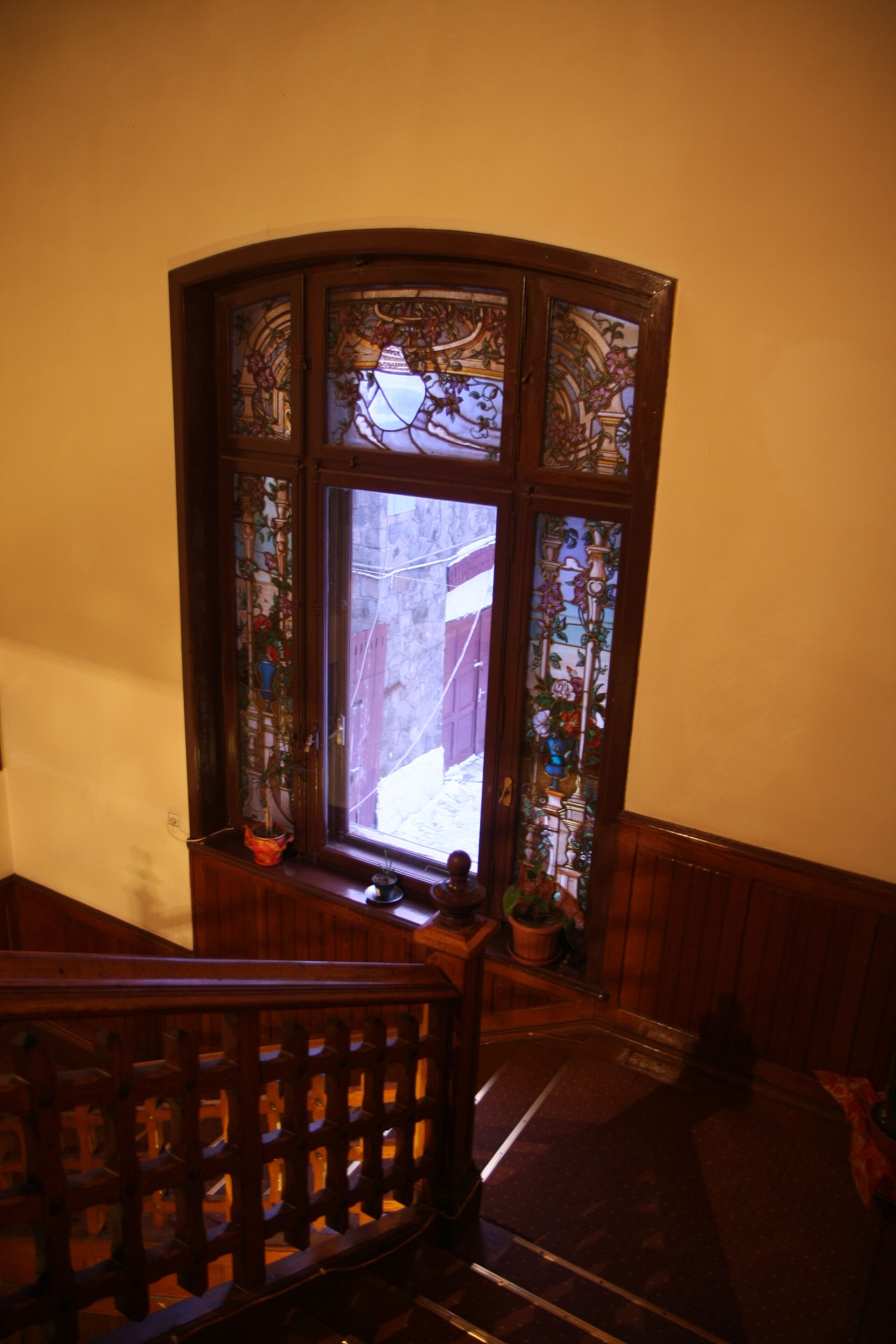 Una escalera de madera con un cristal y detalles ornamentales.