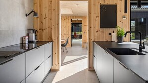 Eine moderne Küche mit Holzvertäfelung, einer schwarzen Arbeitsplatte und einem Spülbecken.