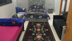 Une chambre à coucher comprenant un lit, une table de chevet, une chaise, un tapis et une armoire.