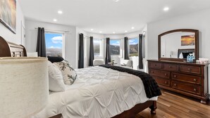 A bedroom with a bed, a dresser, a mirror, and a window with a view. - Gorgeous 4-bedroom house in St. John's perfect for families (St. John's)