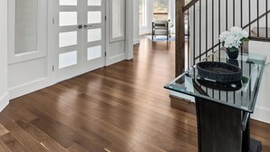 A spacious hallway with a wooden floor, a glass table with a basket, and a staircase with a railing. - Gorgeous 4-bedroom house in St. John's perfect for families (St. John's)