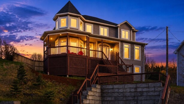 A two-story house with a balcony, a stone staircase, and a wooden deck. - Gorgeous 4-bedroom house in St. John's perfect for families (St. John's)