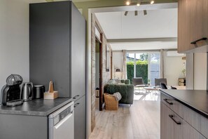 Uma cozinha moderna com cafeteira, chaleira e suporte de utensílios de madeira.