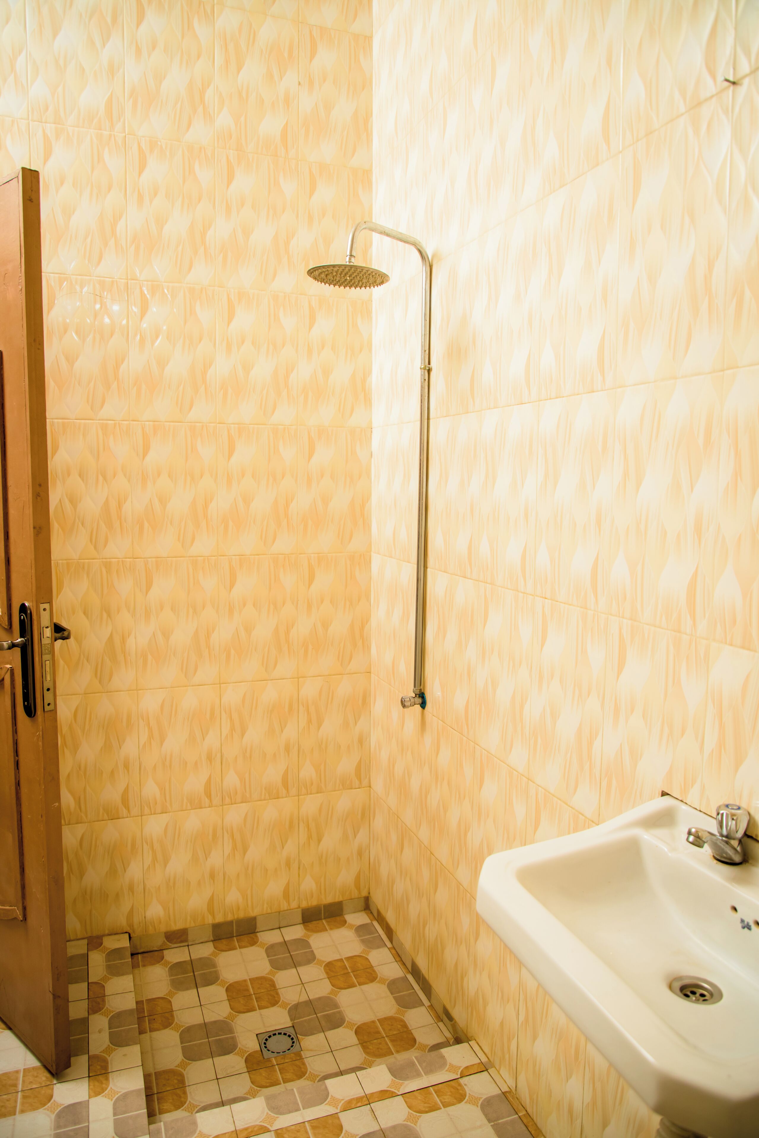 Une salle de bain avec une douche, un lavabo et des carreaux décorés.