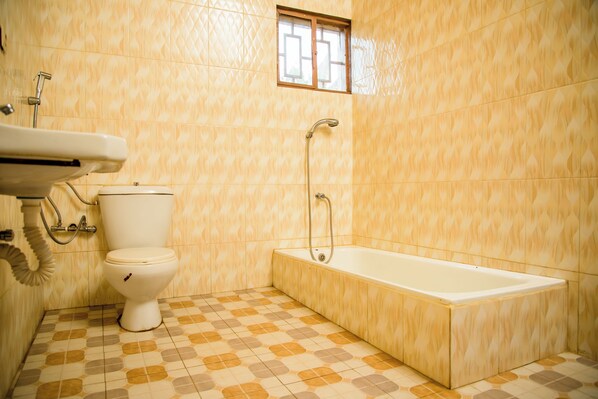 Un baño con inodoro, lavamanos y bañera.