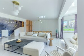 Ein modernes Wohnzimmer mit Sofa, Couchtisch und einer Treppe.