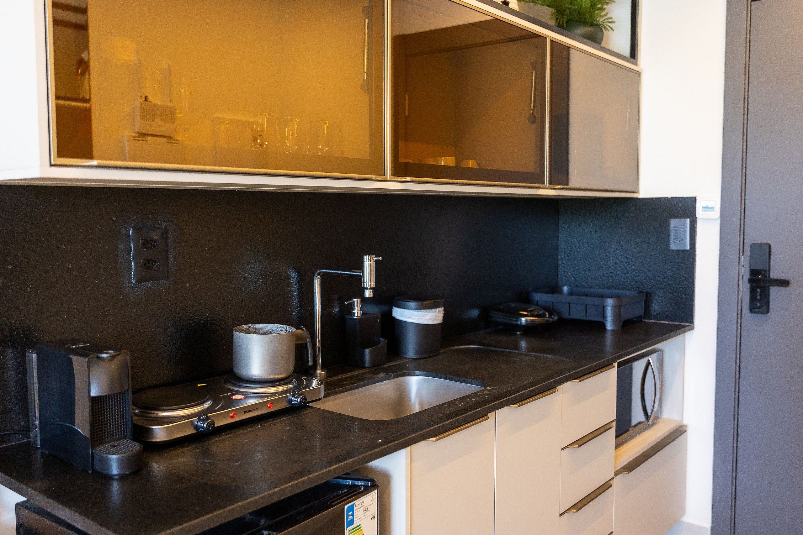 A modern kitchen with a double sink, a coffee machine, and a microwave.