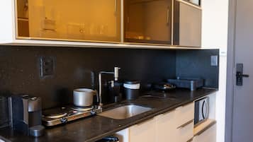 A modern kitchen with a double sink, a coffee machine, and a microwave.