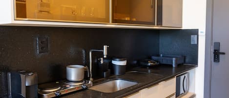 Eine moderne Küche mit einer doppelten Spüle, einer Kaffeemaschine und einer Mikrowelle.