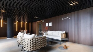 A modern lobby with a sofa, chairs, a coffee table, and a pillar. - Azimut With Direct Beach Access and Sea View by Carpediem (Cabedelo)
