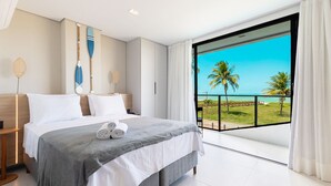 A modern hotel room with a large bed, a view of the ocean, and a balcony with a railing. - Azimut With Direct Beach Access and Sea View by Carpediem (Cabedelo)