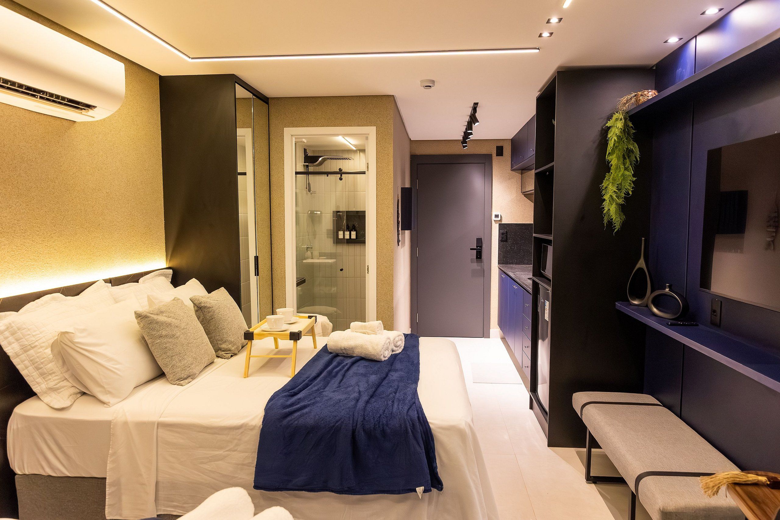 A modern bedroom with a bed, bedside table, and a bench.