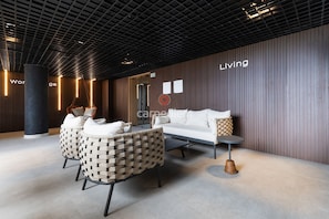 A modern lobby with a sofa, chairs, a coffee table, and a pillar. - Azimut With Direct Beach Access and Sea View by Carpediem (Cabedelo)