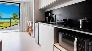 A modern kitchen with a large window, a coffee maker, a microwave, and a pot on the counter. - Azimut With Direct Beach Access and Sea View by Carpediem (Cabedelo)