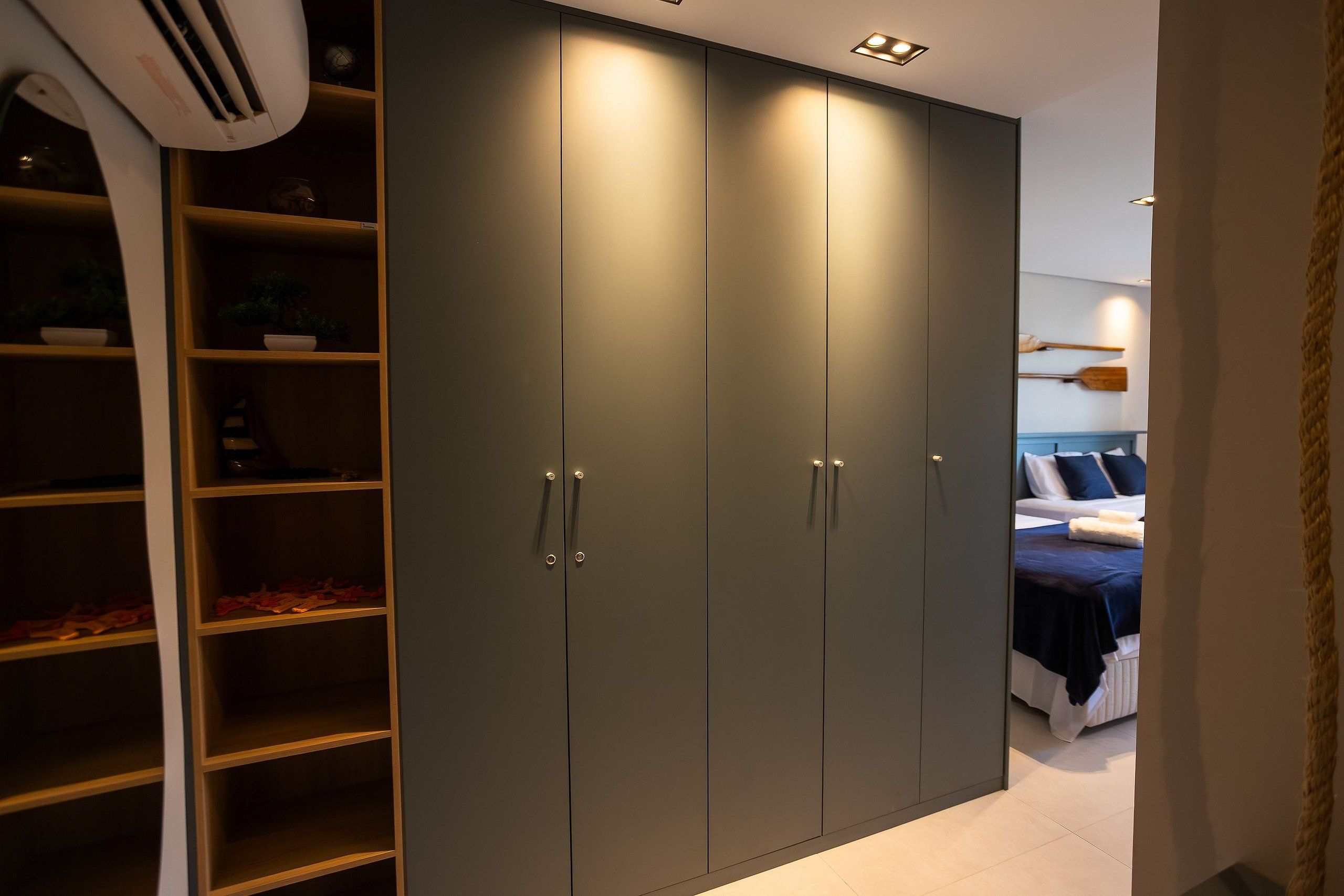 A bedroom with a bed, a bedside table, and a wardrobe with multiple doors.