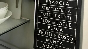 Ravintolan seinällä oleva taulu, jossa on lueteltu tarjolla olevat jäätelölaadut.