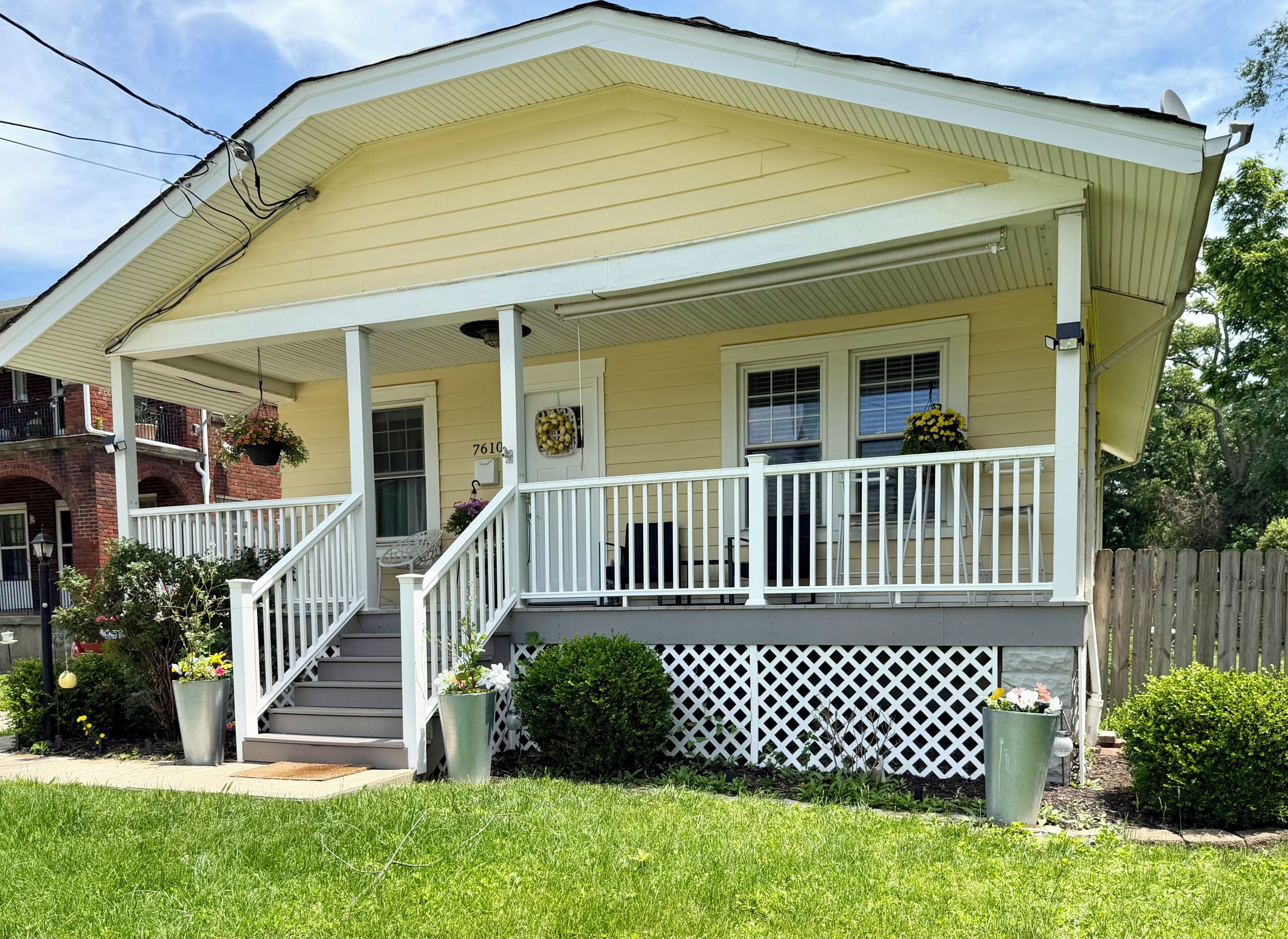 A two-story house with a covered porch, a front door, and a mailbox.