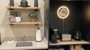 A modern kitchen with a coffee machine, kettle, and tea pot on the counter. - The serenity studio near route 66 (Webb City)