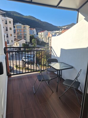 Ein Balkon mit Blick auf eine Stadtlandschaft und Berge.