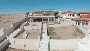 A coastal residential area with modern houses, a central staircase, and a sandy landscape. - Beachfront Home in Rocky Point Casa Alhaja (Puerto Peñasco)