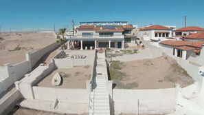 A coastal residential area with modern houses, a central staircase, and a sandy landscape. - Beachfront Home in Rocky Point Casa Alhaja (Puerto Peñasco)