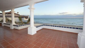 A covered outdoor area with a view of the sea, featuring white columns and terracotta flooring. - Beachfront Home in Rocky Point Casa Alhaja (Puerto Peñasco)