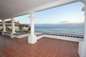 A covered outdoor area with a view of the sea, featuring white columns and terracotta flooring. - Beachfront Home in Rocky Point Casa Alhaja (Puerto Peñasco)