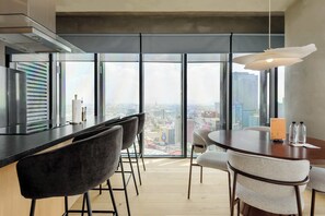 A modern kitchen with a large window, a dining area with chairs, and a view of the city. - w* | Spacious 1BR in Juarez (Ciudad de México)