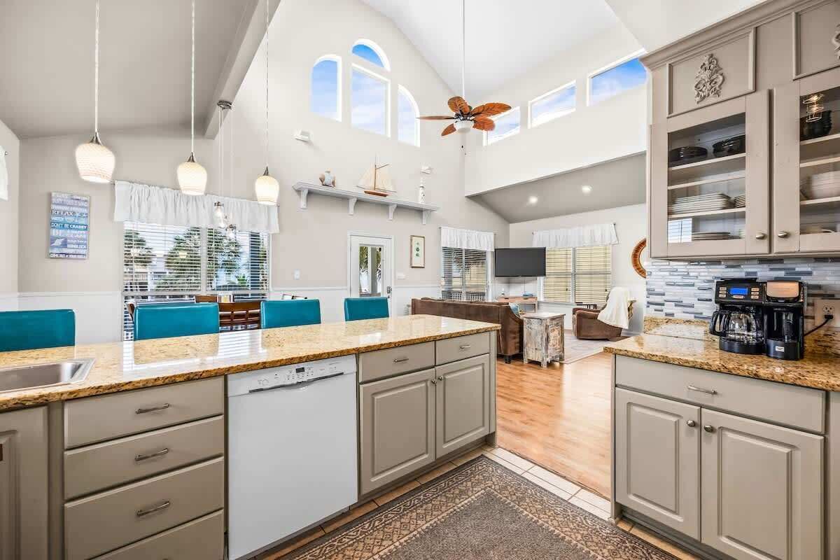 A spacious kitchen with a central island, built-in cabinets, and pendant lighting.
