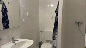 A bathroom with a sink, toilet, and shower.