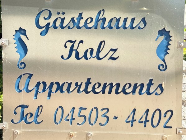 A sign for Gästehaus Kolz Apartments with contact number 04503-4402.
