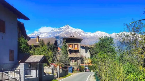 A mountain road with houses and a snow-capped peak in the background. - Belvedere House at the foot of the mountains, welcome our 4-legged friends (Gravere)