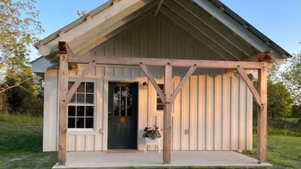 Ein rustikales Holzhaus mit Satteldach und Veranda.