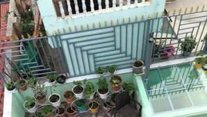 A rooftop terrace with a dining area, potted plants, and a patterned floor. - Full Furnished 2BHK (Kathmandu)