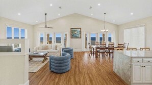 A spacious living area with a dining table, chairs, and a kitchen island. - Beach Front- St George Island -Pool -Game Room (Saint George Island)