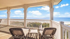 A covered deck with white railings, a view of the beach, and lounge chairs. - Beach Front- St George Island -Pool -Game Room (Saint George Island)