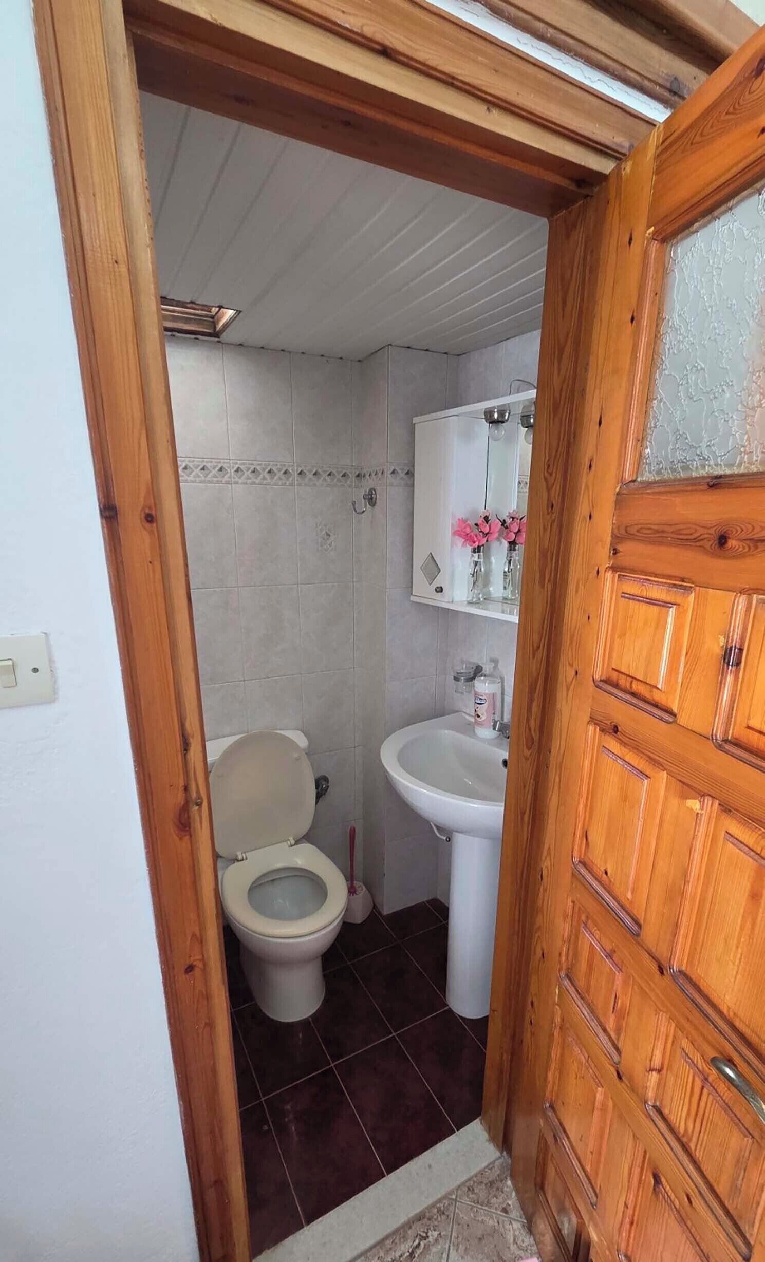 Une salle de bain avec des toilettes, un lavabo et un miroir.