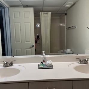 A bathroom with two sinks, a mirror, a shower curtain, and a towel rack. - Amazing view @ Long Beach Resort Tower-1 (Panama City Beach)