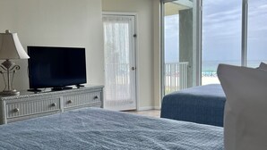 Et soveværelse med fjernsyn, en dør og en balkon med udsigt.