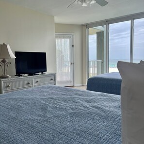A bedroom with a TV, a door, and a balcony with a view. - Amazing view @ Long Beach Resort Tower-1 (Panama City Beach)