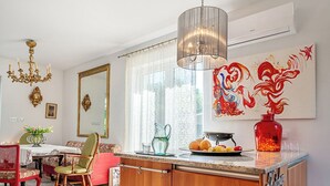 Een moderne keuken met een houten keukeneiland, een kroonluchter en een grote spiegel.