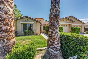 A residential area with two houses, one with a large window and a well-maintained lawn, and a sign that reads 'Alliance'. - Perfect 3-bedroom house with a pool in enjoyable neighborhood (Indio)