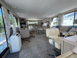 A compact RV interior with a kitchenette, dining area, and seating.