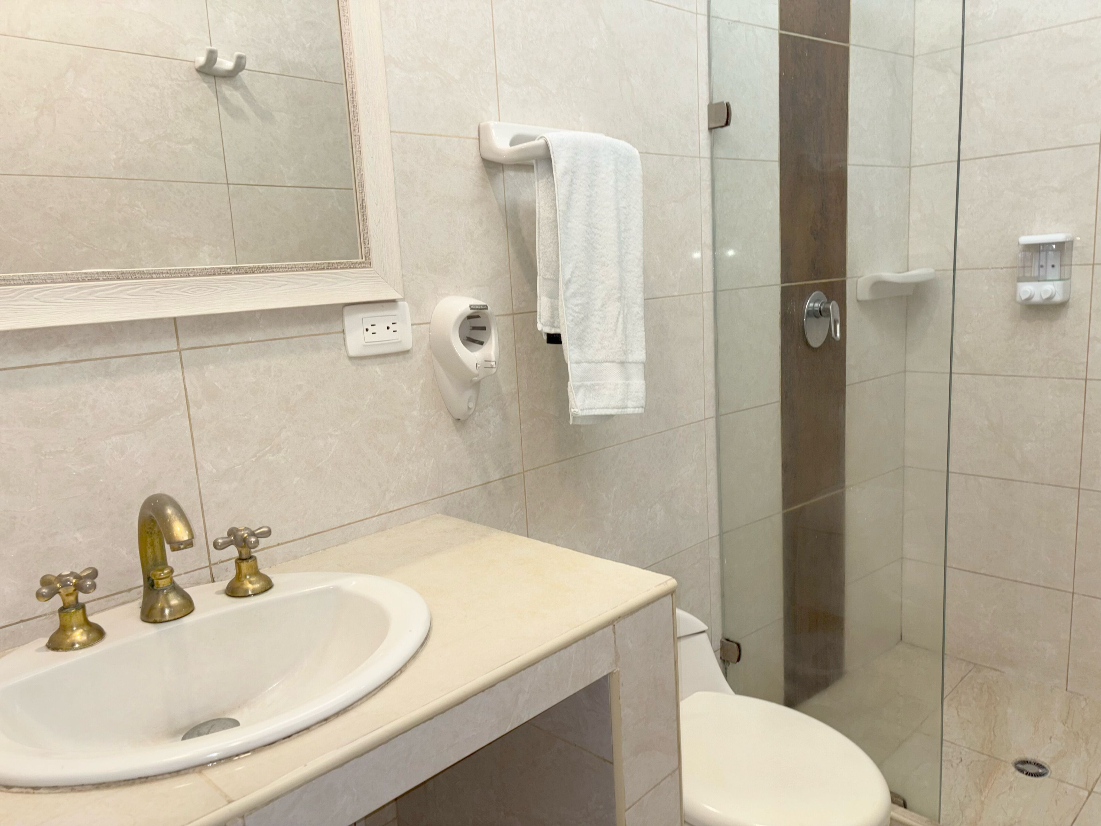 Ein Badezimmer mit Waschbecken, Toilette und Duschkabine aus Glas.