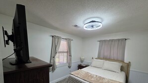 A bedroom with a bed, a dresser, a desk, a lamp, and a ceiling light fixture. - Padgett Peaceful Acres (Andalusia)