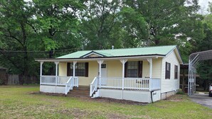 A single-story house with a porch, a covered porch area, and a fenced yard. - Padgett Peaceful Acres (Andalusia)