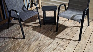 A wooden deck with two chairs and a small table. - Padgett Peaceful Acres (Andalusia)