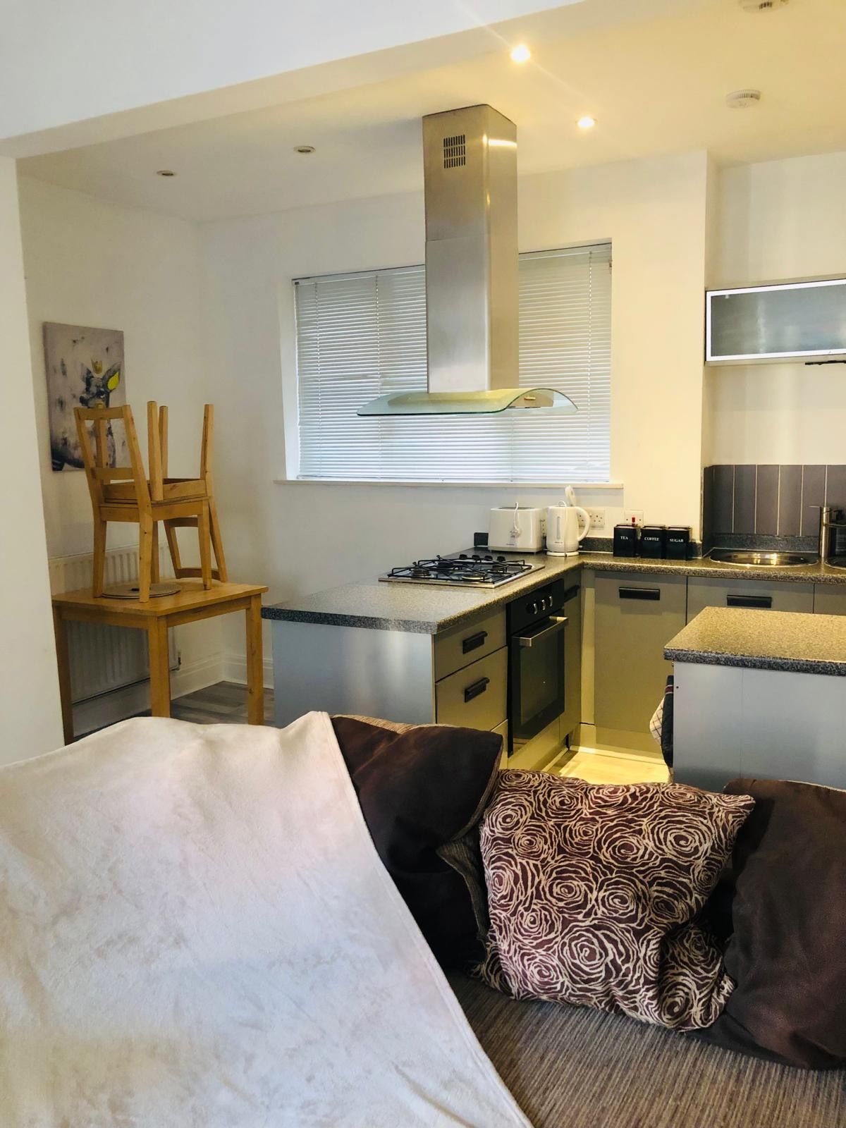 A modern kitchen with a gas stove, oven, and a stainless steel range hood.