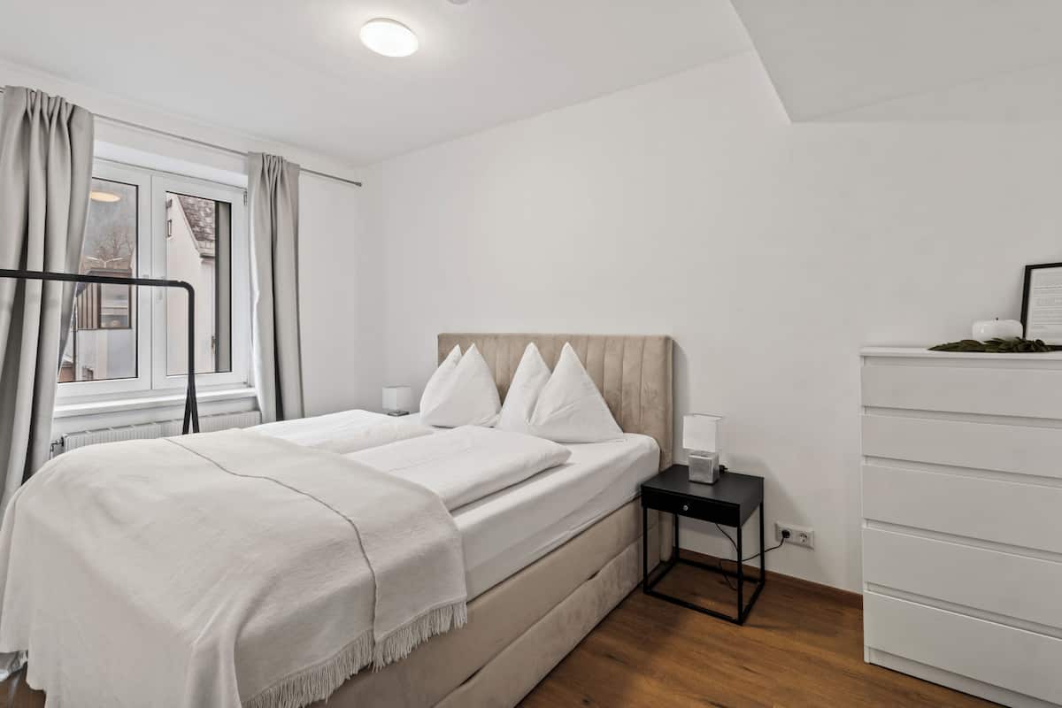 Une chambre à coucher avec un lit, une table de chevet et une commode.